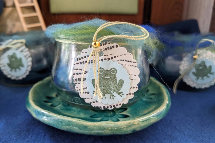 Wetterfrosch im Glas auf einem getöpferten Seifenschälchen